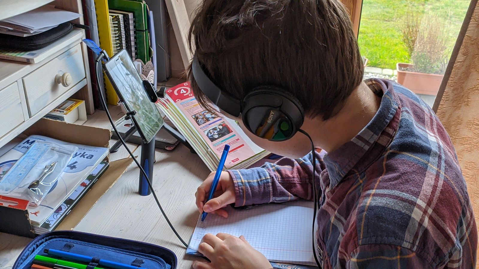 Jongere volgt een online sessie met koptelefoon